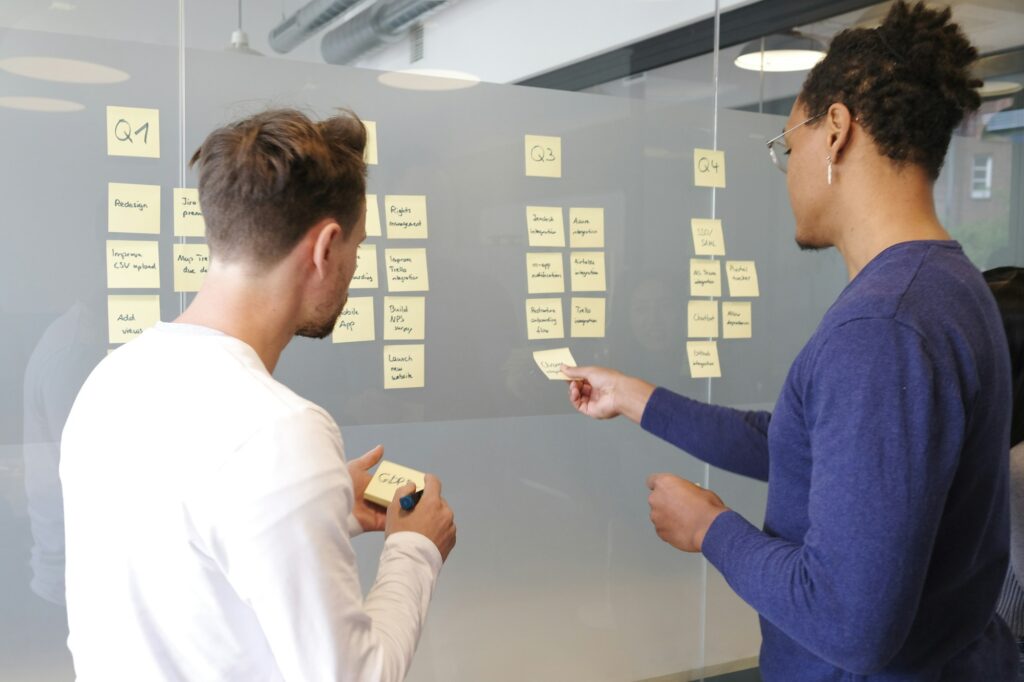 Dos personas analizando información en un muro de trabajo