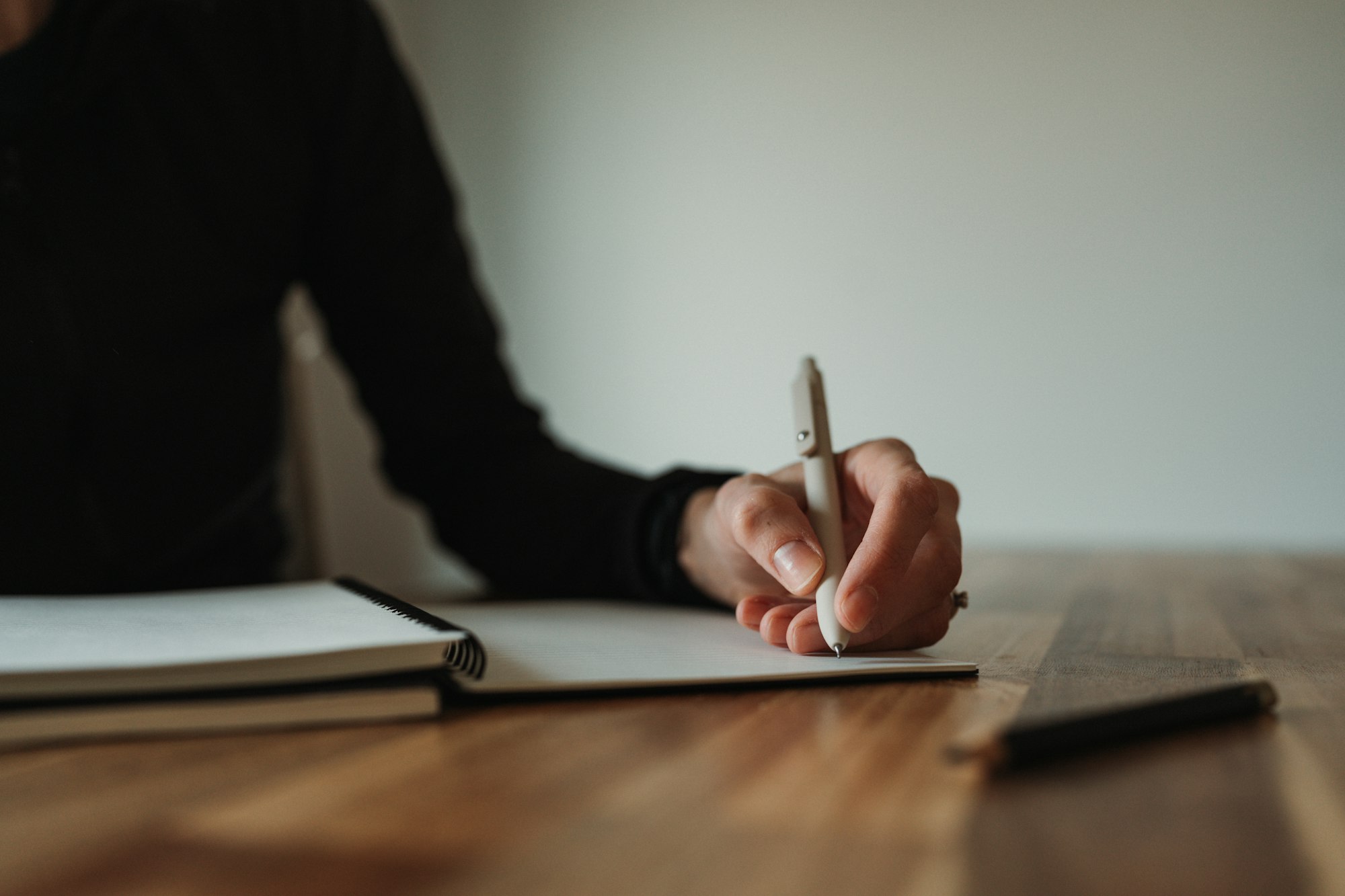 Persona escribiendo notas en un escritorio